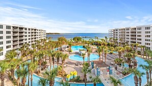 Un complexe hôtelier doté de plusieurs piscines, de palmiers et offrant une vue sur l’océan.