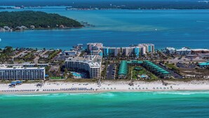 Zona costanera amb hotels a primera línia de platja, un port esportiu i una platja amb ombrelles.