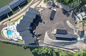 An aerial view of a hotel with a swimming pool, parking areas, and a waterfront. - NEW Luxury Lakefront Condo w 5-star amenities: Pool, SPA, BBQ, GYM, Clubhouse (Lake Ozark)