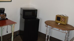 A small room with a microwave, a vintage radio, and a coffee maker on a table. - #14 ONE KING BED in delightful Columbia Falls with WiFi, AC 20 miles from GNP (Columbia Falls)