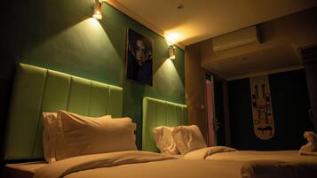 Una habitación de hotel con cabecera verde, un cuadro en la pared y una decoración con una tabla de snowboard.
