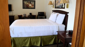 A hotel room with a large bed, a desk with a chair, a television, and a lamp. - #15 ONE QUEEN BED with WiFi and AC in charming Columbia Falls, 20 mi from GNP!! (Columbia Falls)