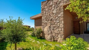 Un edificio in pietra dal design moderno, un vialetto lastricato e aree verdi.
