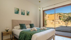 Una camera da letto con un letto grande, un comodino e vista su un edificio in pietra.