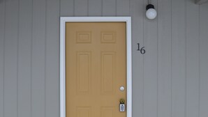 A single-story building with a yellow door and a white frame. - #16 FAMILY SUITE , 3 BEDS with WiFi, and AC in Columbia Falls, 20 mi to GNP (Columbia Falls)