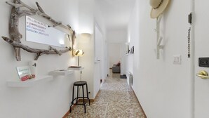 A hallway with a rustic decor, including a branch wall art, a hanging hat, and a sign with social media information. - Apartment 'Amy Home' with Balcony, Wi-Fi and Air Conditioning (Roma)