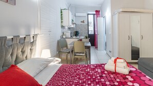 A bedroom with a bed, a desk, a chair, and a wardrobe.