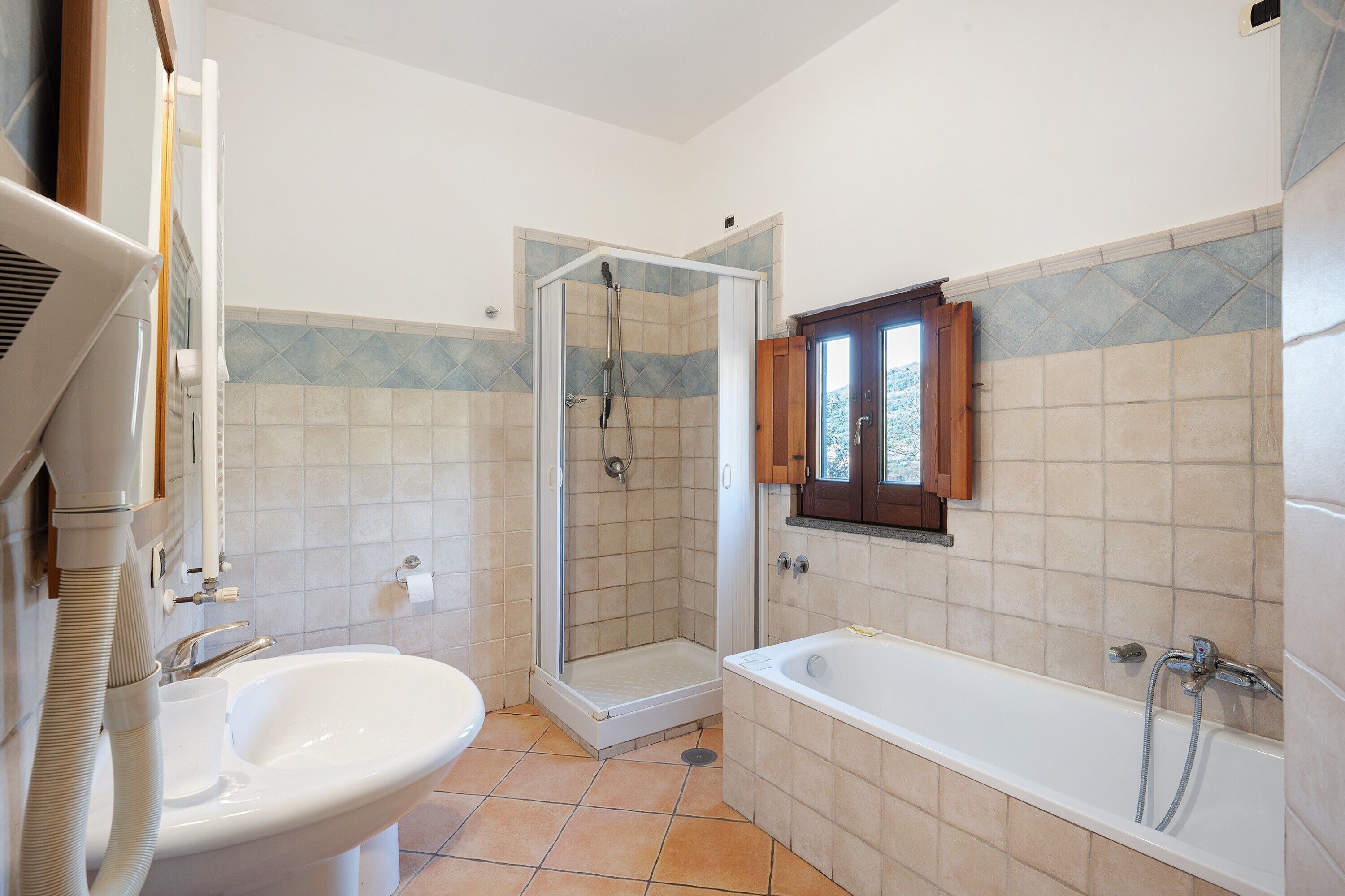 A bathroom with a shower, a sink, and a bathtub.