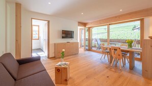 Un salon moderne comprenant un canapé, une table basse en bois et un coin repas avec une table et des chaises.