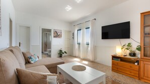 A living room with a sofa, a coffee table, a TV, and a cabinet. - Vacation Home 'Buganvilla' with Sea View and Wi-Fi (Pájara)