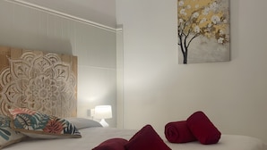 A hotel room with a bed, pillows, a lamp, and artwork on the walls. - Vacation Home 'Buganvilla' with Sea View and Wi-Fi (Pájara)