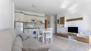 A modern apartment with a living room, kitchen, and dining area. - Escapada Al Sur Vacation Apartment with Wi-Fi (Morro del Jable)