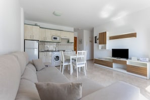 Un appartement moderne comprenant un salon, une cuisine et un coin repas.