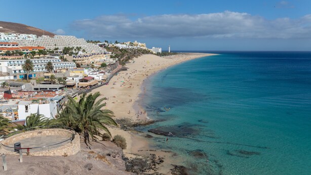A coastal town with a beach, buildings, and clear blue water. - Escapada Al Sur Vacation Apartment with Wi-Fi (Morro del Jable)