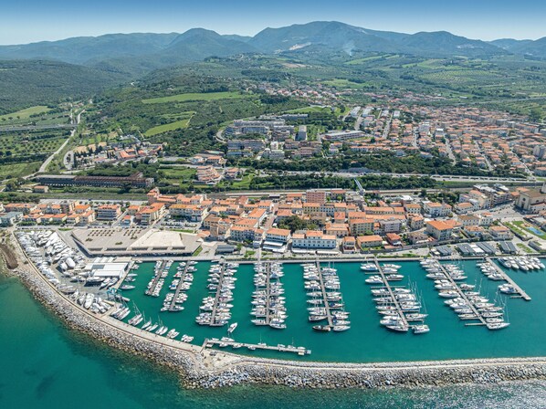 A coastal town with a marina, buildings, and surrounding greenery.
