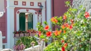 A building facade with a decorative archway, a green door, and flower boxes. - Villa 'Luxury  Soleluna Con Jacuzzi' with Sea View, Wi-Fi and Air Conditioning (Praiano)