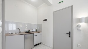 A modern kitchen with a dishwasher, a sink, and a door with a handle.