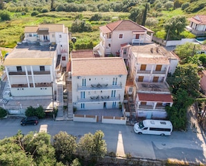 Zona residencial com edifícios altos, uma rua e veículos estacionados.