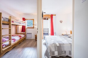 Un dormitorio con camas literas, una ventana con vistas, un calentador y una decoración con forma de corazón en la pared.