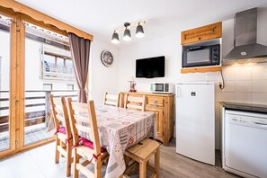 Una cocina con microondas, refrigerador y armarios de madera.