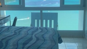 A bedroom with a large window offering a view of the ocean and a distant island. - Condo with Amazing Ocean View in Fajardo near Villa Marina (Fajardo)
