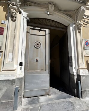 A building entrance with a large door, a security camera, and a no parking sign. - Apartment 'Gammazita' with Wi-Fi and Air Conditioning (Catania)