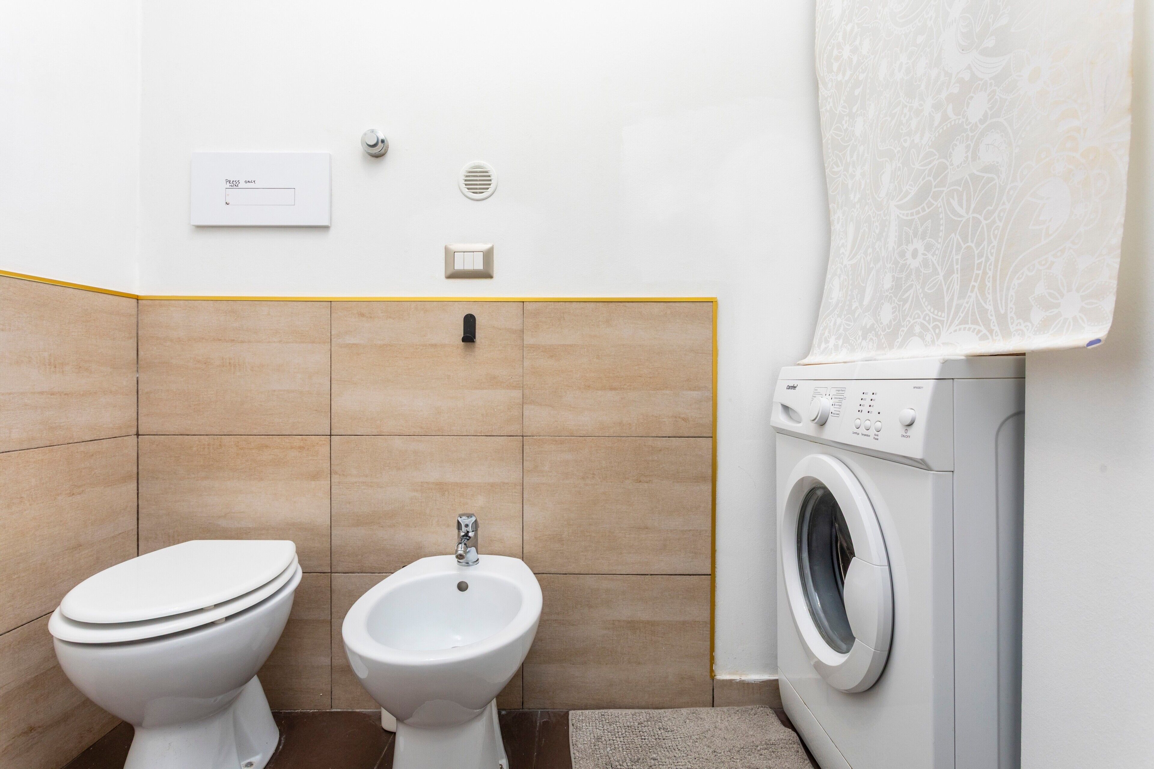 Un baño con inodoro, bidé y lavadora.