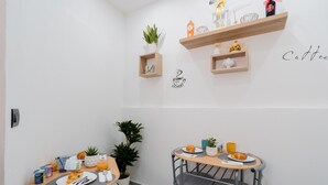 A small dining area with two tables, each with a chair, a potted plant, and a coffee cup. - 'Luxury 12 - Room Aurora' with Shared Terrace, Wi-Fi and Air Conditioning (Tuglie)