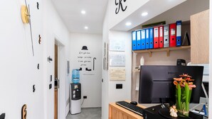 A reception desk with a computer, a water dispenser, and a wall with a quote and certificates. - 'Luxury 12 - Room Aurora' with Shared Terrace, Wi-Fi and Air Conditioning (Tuglie)
