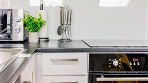 Eine moderne Küche mit Edelstahlgeräten, einer Pflanze und einer Kaffeemaschine.
