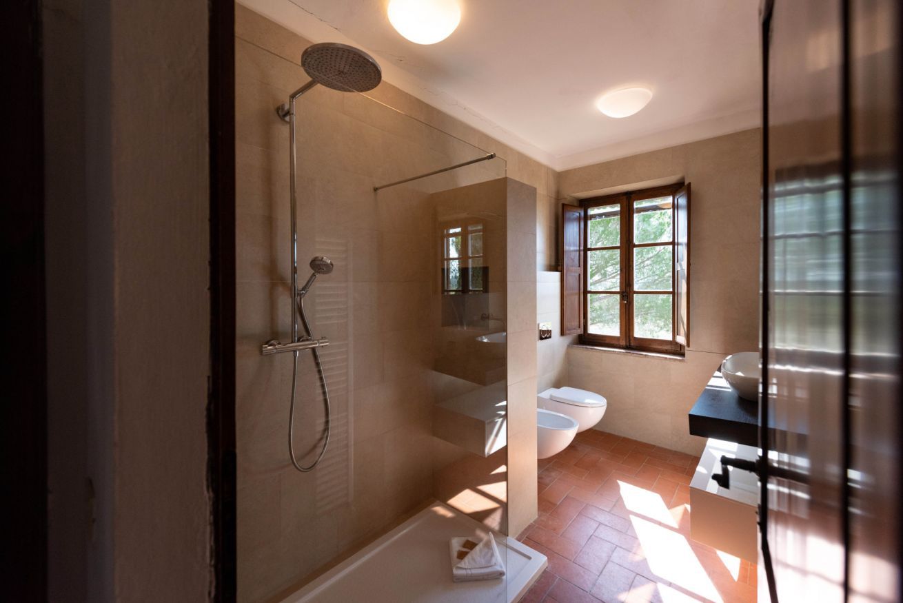 Une salle de bain moderne avec une douche à parois de verre, des toilettes et un lavabo.