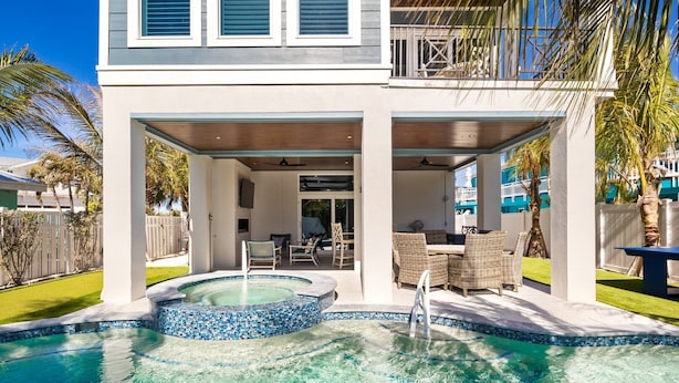 A two-story house with a swimming pool, outdoor seating area, and a covered patio. - Salt Dreams: 1 Block to Beach! Pool, Spa, Games, Rooftop Deck by Anna Maria Life Vacation Rentals (Anna Maria)