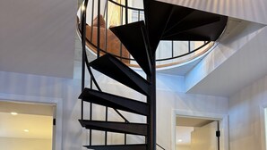 Ein modernes Interieur mit einer Wendeltreppe, einem schwarzen Schrank und einem Sitzsack.