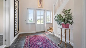 A hallway with a patterned rug, a potted plant, and a staircase. - 2 bedroom nice home in Hemmet (Hemmet)