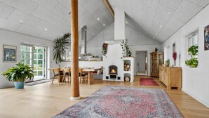 Un salon spacieux doté d’une cheminée, de parquet et d’un grand tapis.