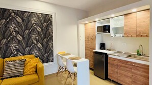 A compact living space with a sofa, dining table, and kitchenette. - Palapa Suite # 7, walk to Eagle Beach (Eagle)