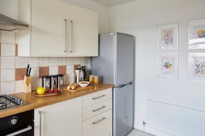 A modern kitchen with a stainless steel refrigerator, wooden countertop, and a tiled backsplash. - Countryside Views | Garden | Pets + Family | 50"TV (Queensbury)