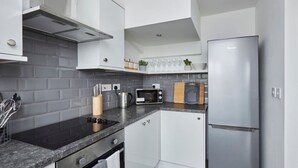 A modern kitchen with white cabinets, a stainless steel refrigerator, a microwave, and a built-in oven. - Halifax+Piece Hall 4 min| Parking | Pets OK|Garden (Halifax)