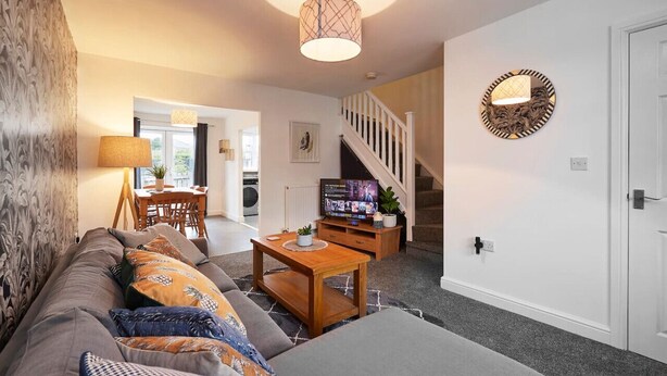 A living room with a sofa, coffee table, TV, and a staircase leading to another room. - Halifax+Piece Hall 4 min| Parking | Pets OK|Garden (Halifax)