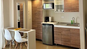 A modern kitchen with a built-in dishwasher, a microwave, and a sink. There is a dining area with a table and chairs. - Palapa Suite # 8, walk to Eagle Beach (Eagle)