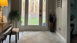 A spacious entryway with a large door featuring a stained glass design, a marble floor, and a view of the outdoors through a window above the door. - Charming spacious home nestled on a private lot minutes away from the Masters (Augusta)