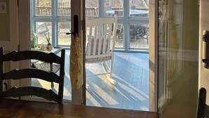 A room with a wooden dining table and chairs, a white chair outside the door, and a sign above the door that reads "Home is Our Happy Place". - Charming spacious home nestled on a private lot minutes away from the Masters (Augusta)