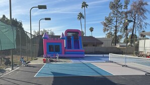 Ein Basketballplatz mit einer bunten, aufblasbaren Spielkonstruktion im Hintergrund.
