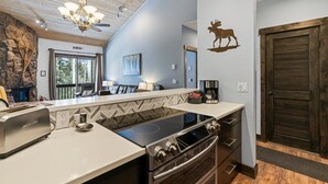 A modern kitchen with a built-in stove, a dining area with a view, and a rustic decor including a moose wall decal. - Hot Tub & Pool, Pickle Ball, Hiking/Fishing Close! (Durango)