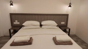 A neatly made bed with two pillows, two bedside tables, and two wall-mounted lights. - Nirili Villa (Dhiffushi)