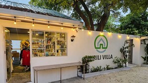 A storefront with a sign reading "MARRILI VILLA" and a display of various items inside. - Nirili Villa (Dhiffushi)