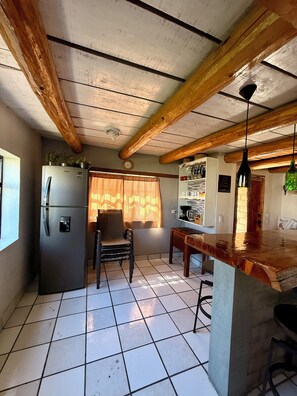 Enjoy cooking in this kitchen with a refrigerator, dining table, and bar counter.