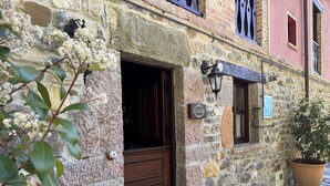Ein Steinhaus mit einer Holztür, einem Blumentopf und einem Schild mit der Aufschrift 'La Cocada'.