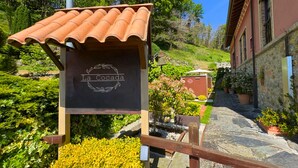 Ein rustikaler Außenbereich mit einer Holzpergola, einem Schild mit der Aufschrift 'La Cocada' und einem Steinweg, der zu einem Gebäude führt.