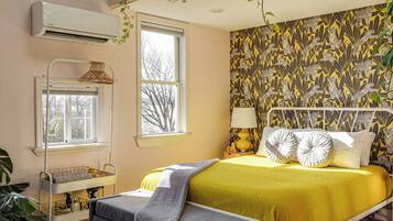 Un dormitorio con cama, lámpara de noche y ventana.